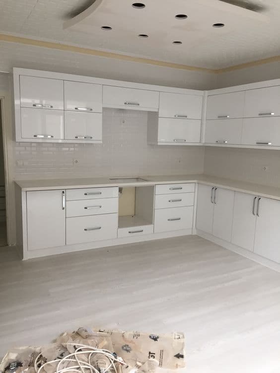White gloss kitchen cabinetry, installation in progress