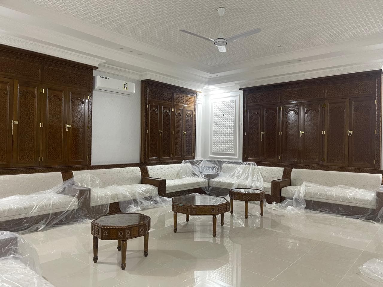 Private majlis with carved wood paneling and custom cabinetry